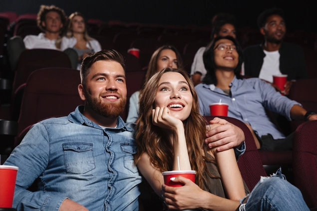 Un couple de personnes regardent un film dans une salle de cinéma